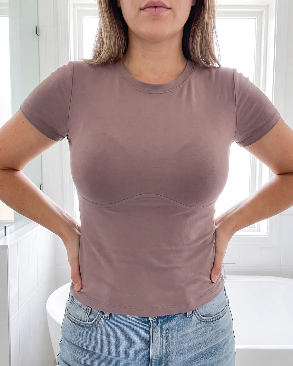 Femme à poitrine moyenne en t-shirt moulant avec un soutien-gorge à armature : une marque se voit sous la poitrine