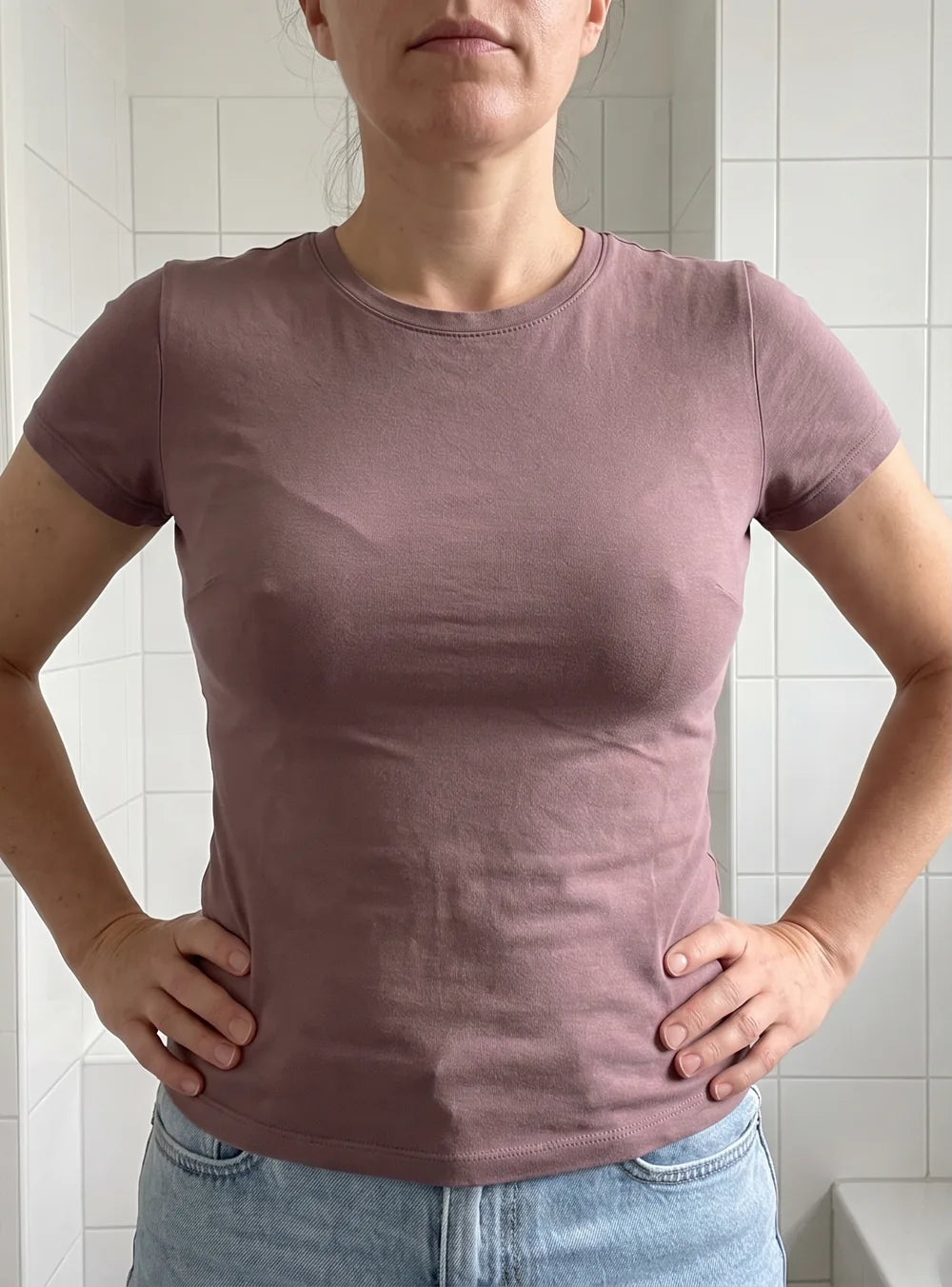 Femme à poitrine moyenne en t-shirt moulant avec un soutien-gorge à armature : une marque se voit sous le tissu