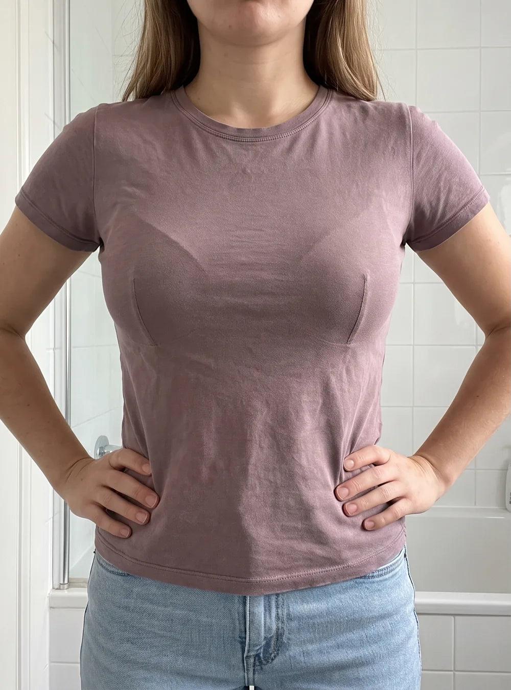 Femme à petite poitrine en t-shirt moulant avec un soutien-gorge à armature : une marque se voit sous le tissu